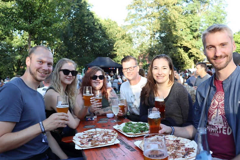 Sechs Personen beim Bieranstoß in gemütlicher Runde