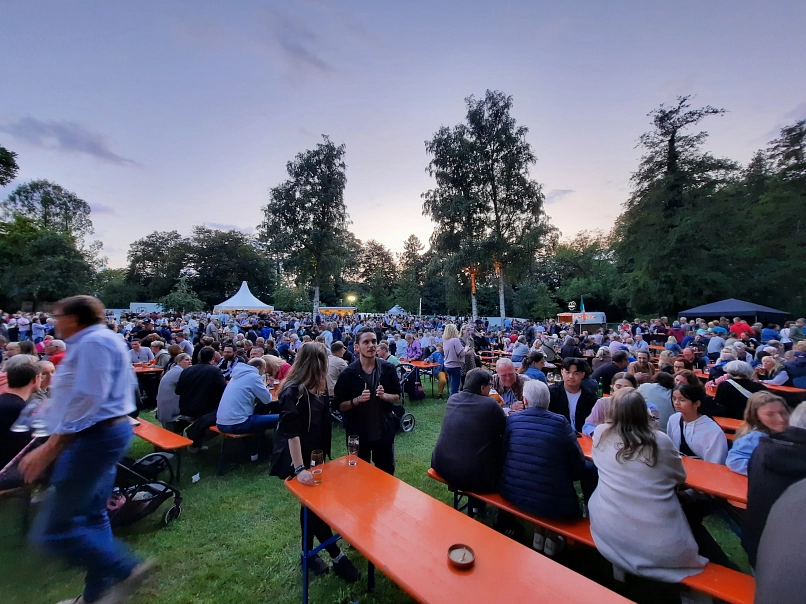 Das Bild zeigt den Klosterpark mit vielen Besucher:innen  beim Bierzauber in der Dämmerung.