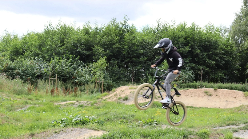 Bikepark Ahlerstedt mit springendem Biker Biker mit Helm, der auf unebenem Gelände mit dem Mountainbike springt. © Stadtmarketing Harsefeld
