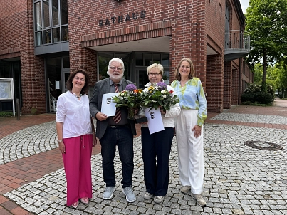 Vier Personen stehen vor dem Harsefelder Rathaus. Die Geehrten halten jeweils einen Blumenstrauß und die Urkunde in der Hand.&nbsp;&copy;&nbsp;Samtgemeinde Harsefeld