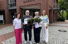 Vier Personen stehen vor dem Harsefelder Rathaus. Die Geehrten halten jeweils einen Blumenstrauß und die Urkunde in der Hand.