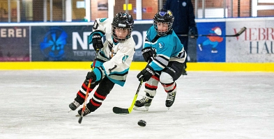 Zwei Kinder spielen Eishockey