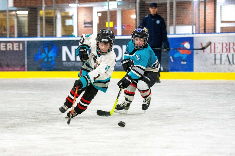 Zwei Kinder spielen Eishockey