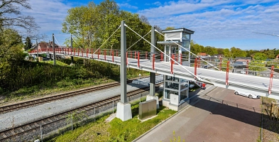 Die Fußgänger- und Radfahrbrücke spannt sich über die Bahngleise.