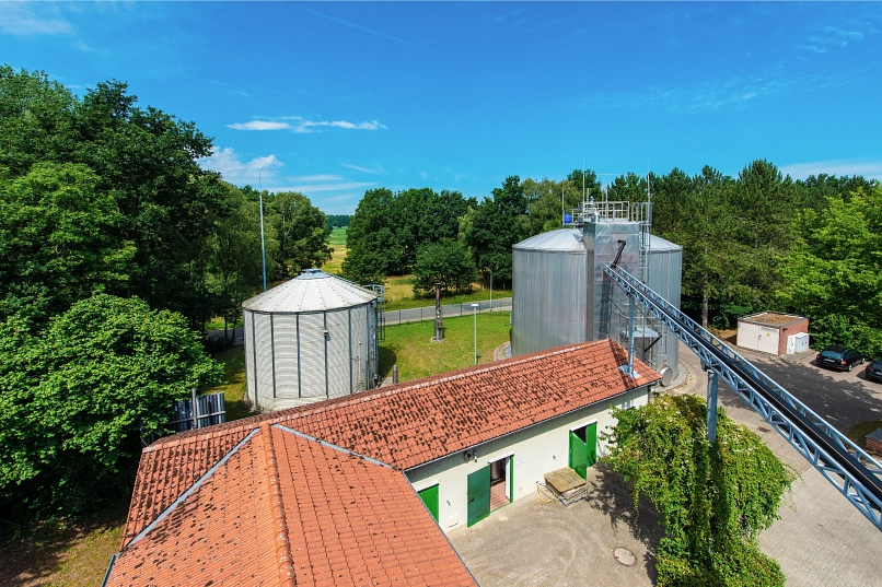 Zu sehen ist eine Luftbild eines Teilbereiches der Kläranlage in Harsefeld mit Faulturm und Maschinenhaus mit Blockheizkraftwerk samt Gasspeicher.