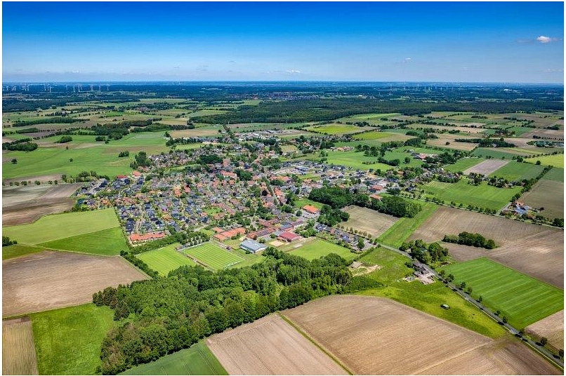 Luftbild Ahlerstedt Es handelt sich um eine Luftbildaufnahme von Ahlerstedt. Es ist der gesamte Ort mit den darumliegenden Feldern, Wäldern und Natur zu sehen; im oberen Bereich ein strahlend blauer Himmel. © Martin Elsen
