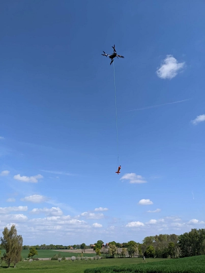 Multikopter mit der Messsonde Am Himmel fliegender Hubschrauber mit herabhängender Messsonde. © Forschungsvorhaben GeoMetEr