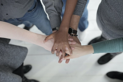 Mehrere Personen stehen und stapeln ihre Hände übereinander.&nbsp;&copy;&nbsp;Foto von Andrea Piacquadio auf Pexels