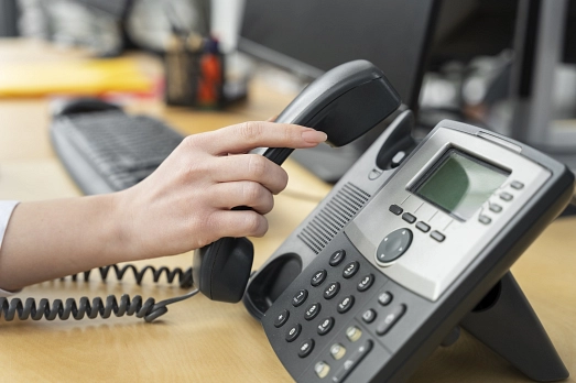 Eine Damenhand greift nach einem Telefonhörer&nbsp;&copy;&nbsp;Freepik